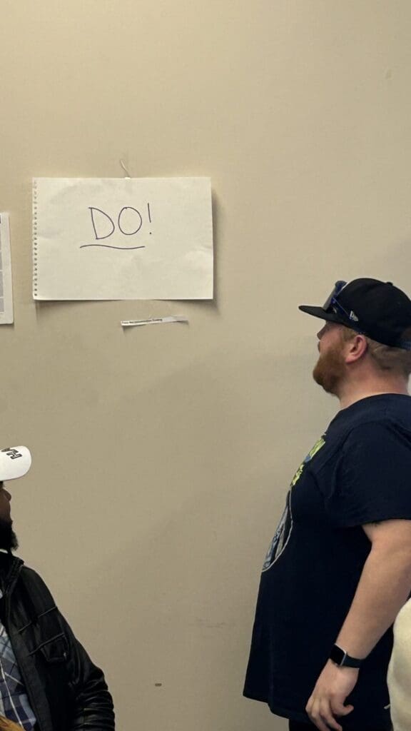 Man looking at a wall with a paper labeled 'DOI'.