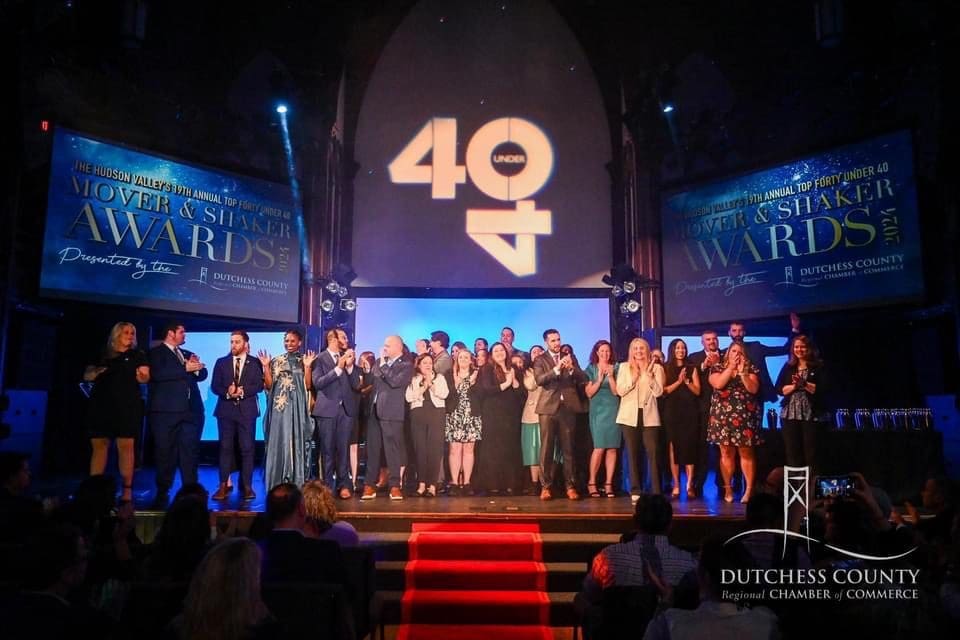 Group photo on stage celebrating a 40th anniversary event.