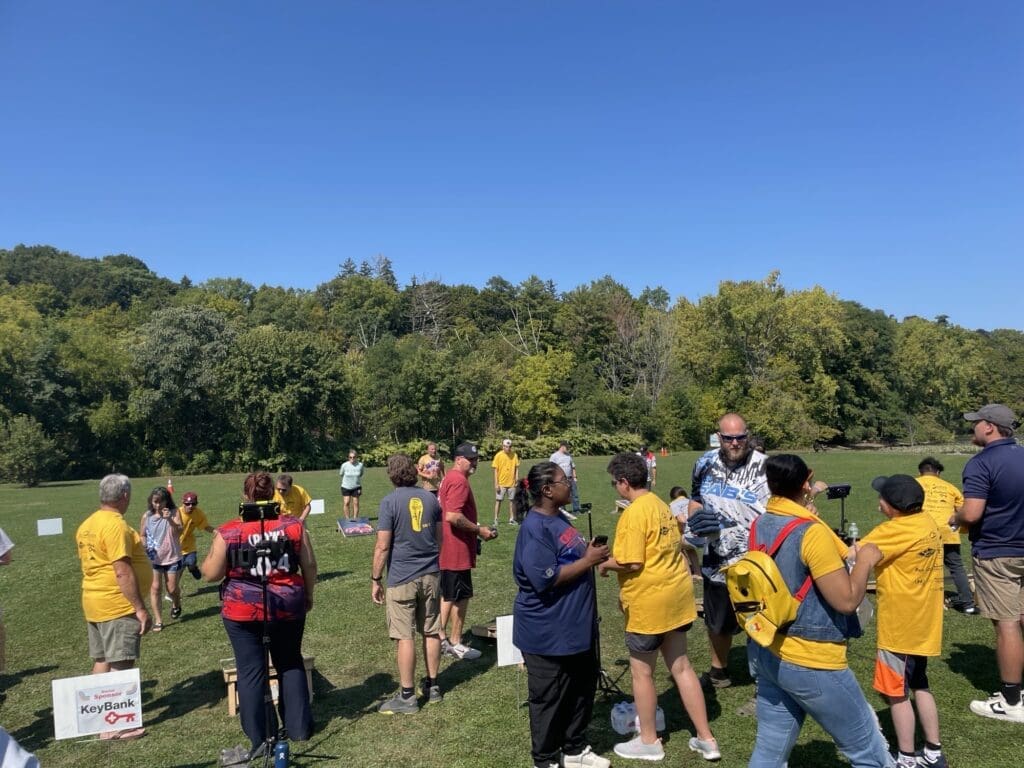 Group of people socializing outdoors on a sunny day in a park.