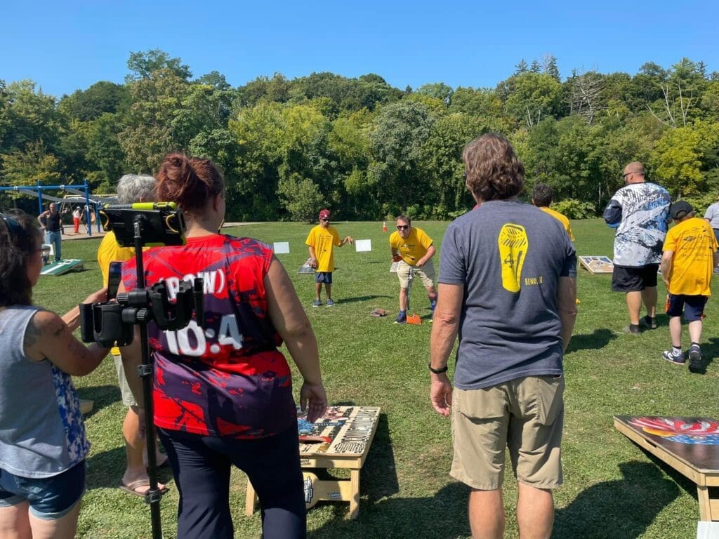 People playing disc golf on a sunny day outdoors.