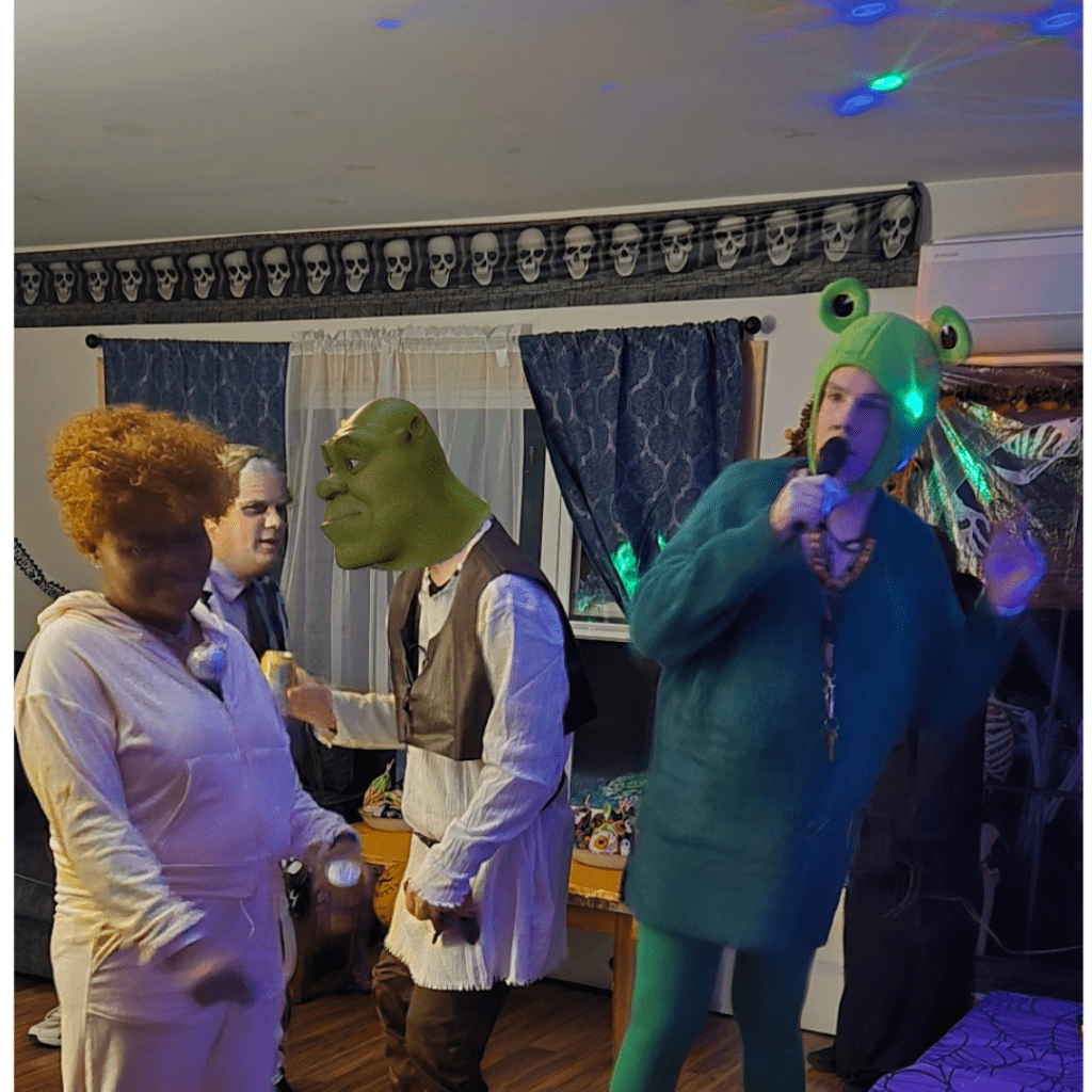 People dressed as Shrek, Donkey, and others at a party.