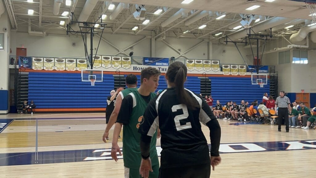 Players preparing for a basketball game in a gymnasium.