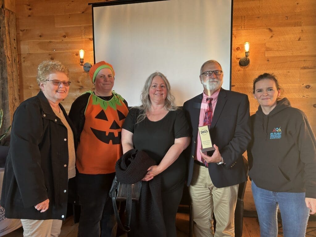 Group of five people posing indoors with festive Halloween attire.