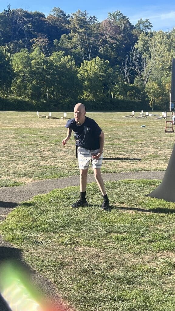 A boy playing frisbee in a park on a sunny day.