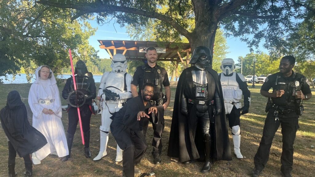 Group dressed as Star Wars characters posing outdoors in daylight.