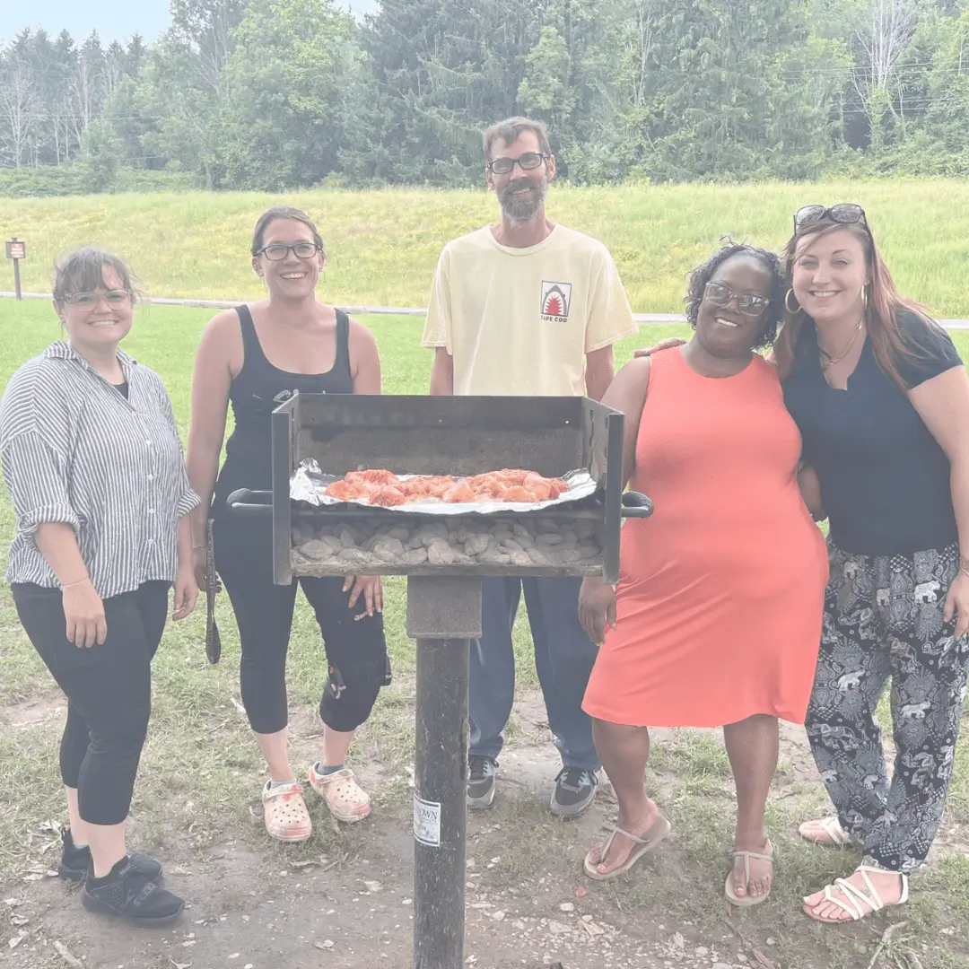 Group enjoying outdoor barbecue in park.