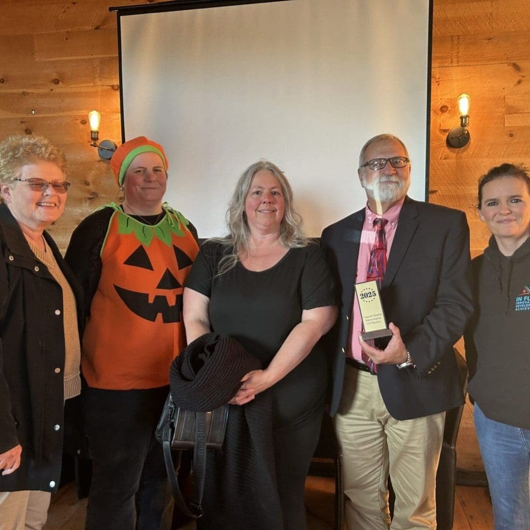 Group of five people posing indoors with festive Halloween attire.
